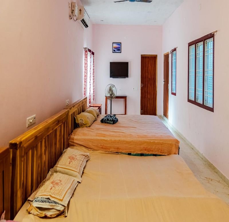 Long group bedroom with three large wooden beds in a row