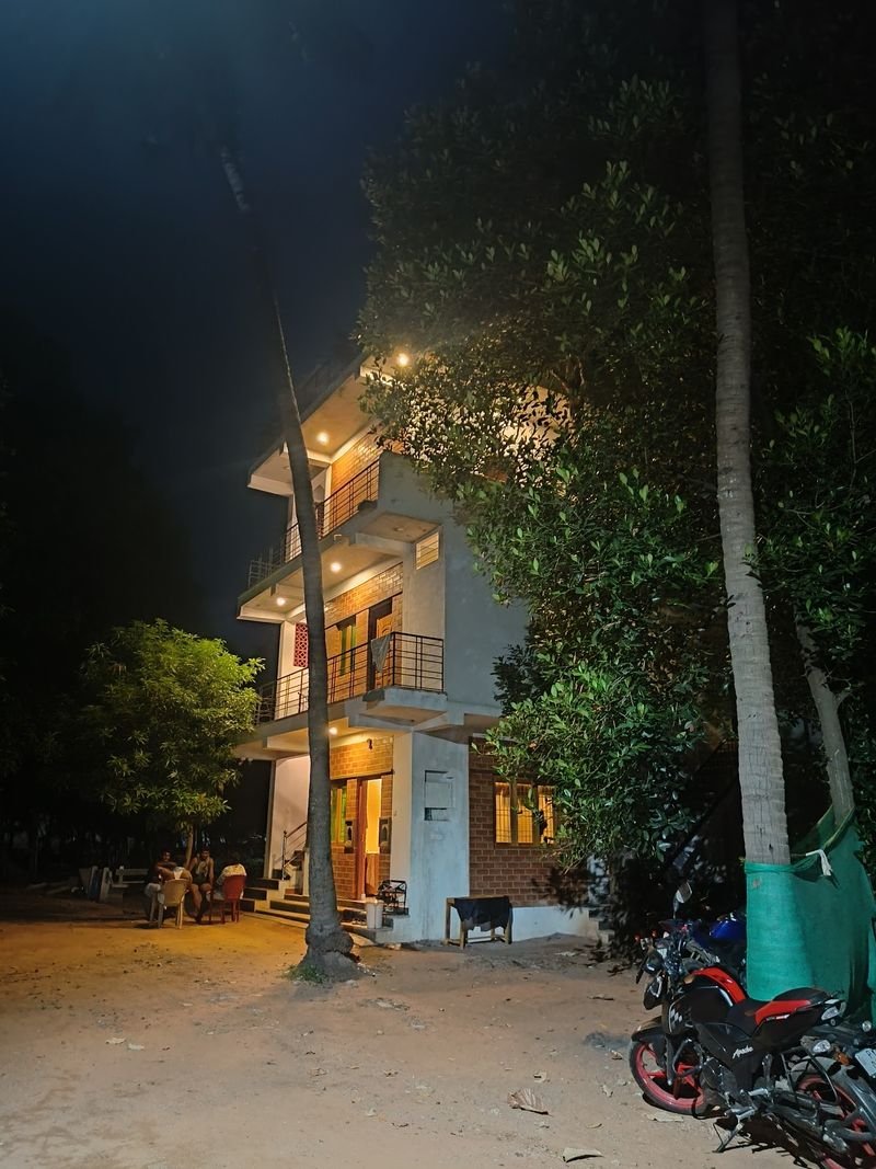 The farmhouse at night with lights glowing on every floor